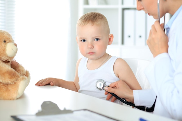 Врач осматривает ребенка с помощью стетоскопа