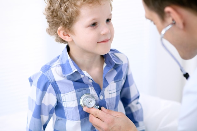 Photo doctor examining a child  patient by stethoscope