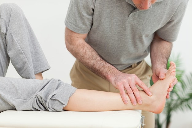 Doctor examining the foot of a woman