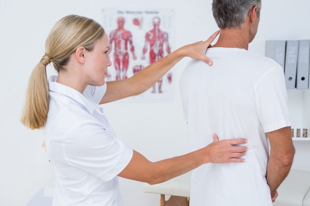 Doctor examining her patient back 