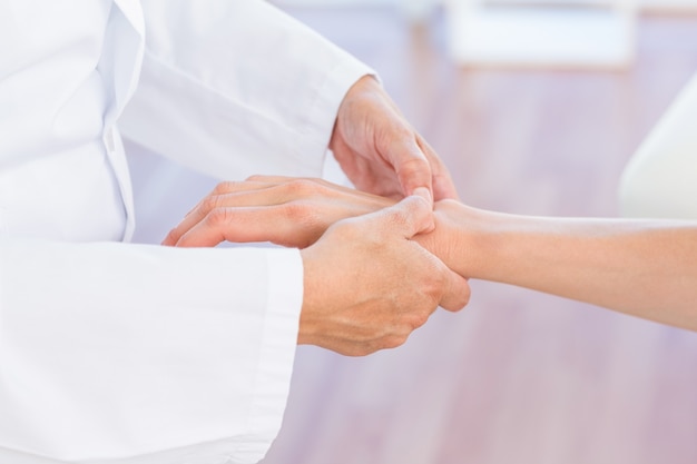 Doctor examining her patients wrist