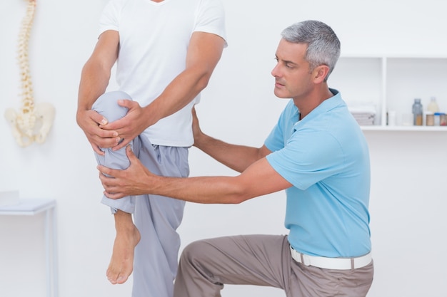 Doctor examining his patient legs