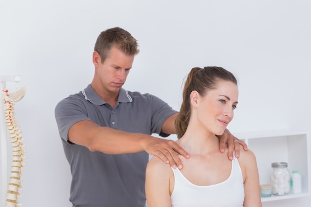 Doctor examining his patient neck 