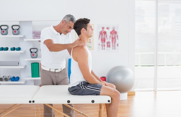 Doctor examining his patient neck 