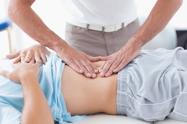 Doctor examining his patient stomach