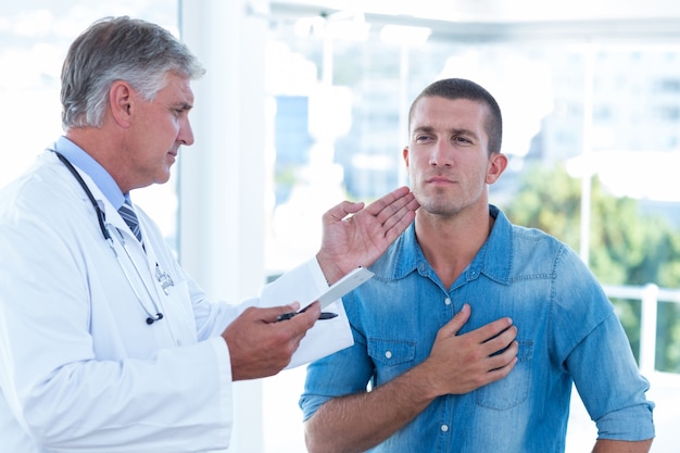 Foto medico esaminando il collo dei suoi pazienti