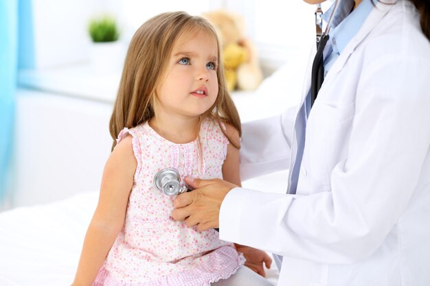 Foto medico che esamina una bambina con lo stetoscopio.