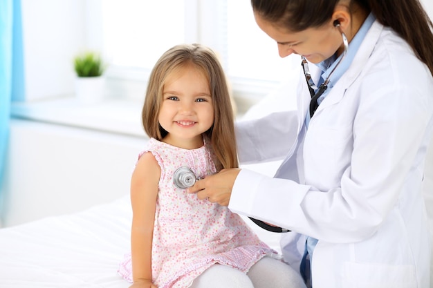 Doctor examining a little girl by stethoscope