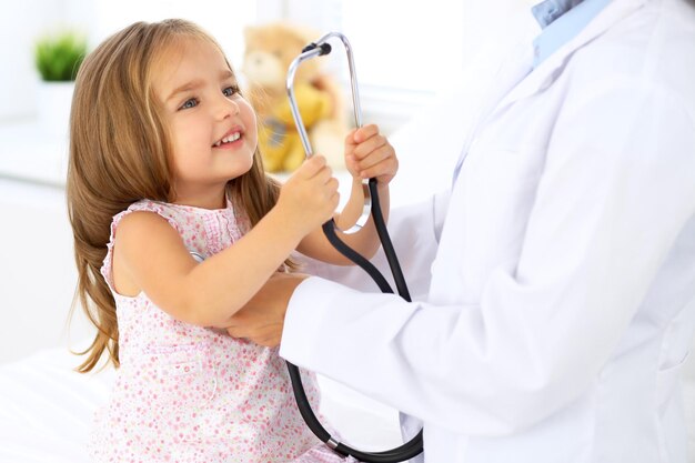 Doctor examining a little girl by stethoscope