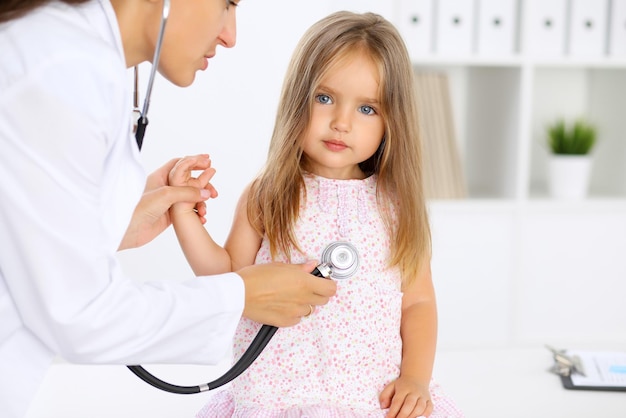 Doctor examining a little girl by stethoscope