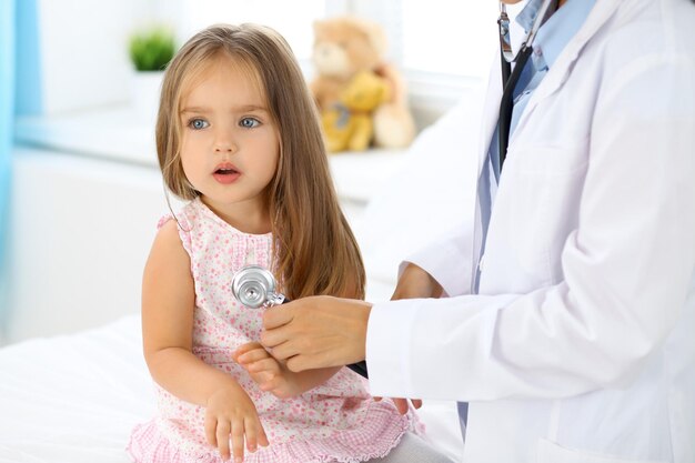 Doctor examining a little girl by stethoscope.