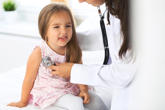 Doctor examining a little girl by stethoscope.