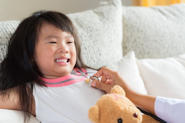 Doctor examining a little girl by using stethoscope.