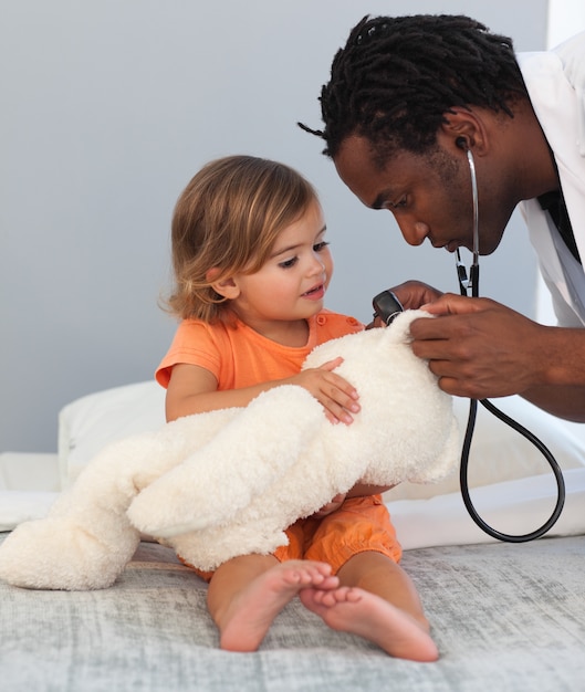 Doctor examining a little girl at hospital