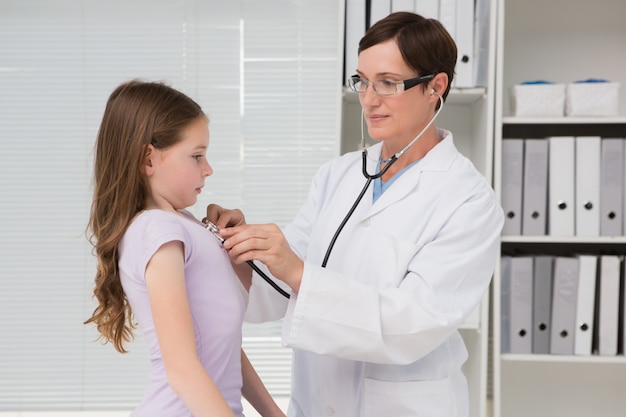 Doctor examining little girl