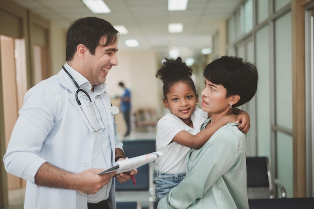 Doctor examining little patient with mother