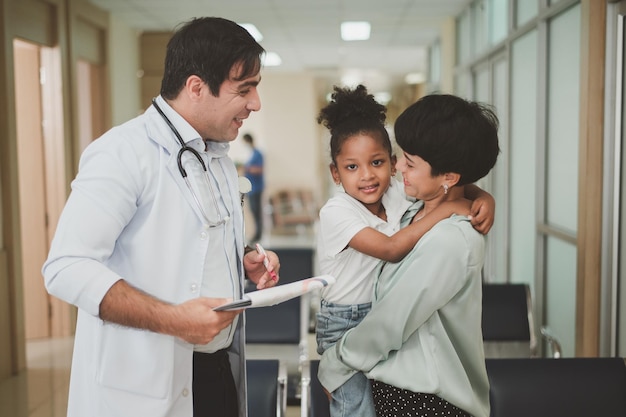 Doctor examining little patient with mother