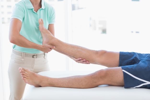 Doctor examining man leg 