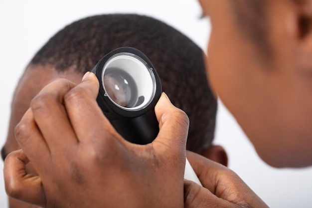 Photo doctor examining man's hair with dermatoscope