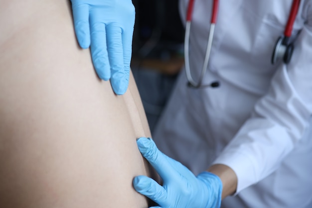 Doctor examining patient spine in clinic closeup