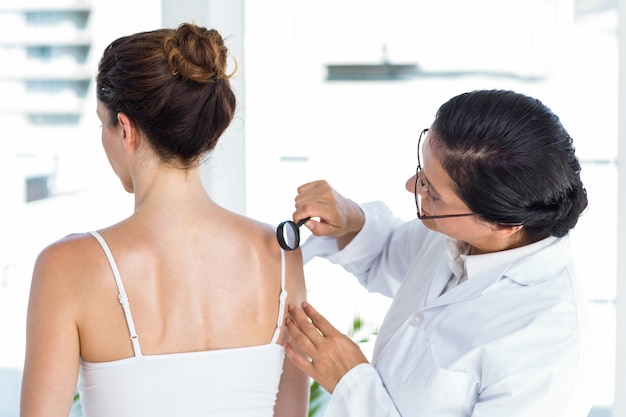 Doctor examining patient with magnifying glass