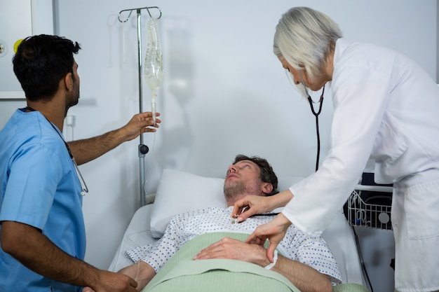 Doctor examining a patient with a stethoscope while checking glucose bottle