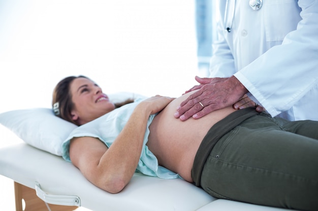 Doctor examining pregnant woman in clinic