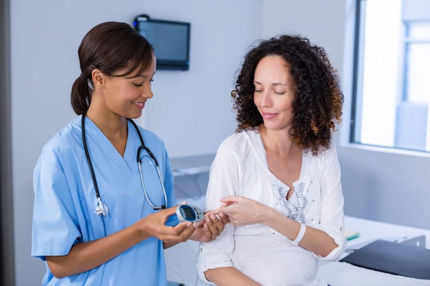 Doctor examining pregnant womans blood sugar