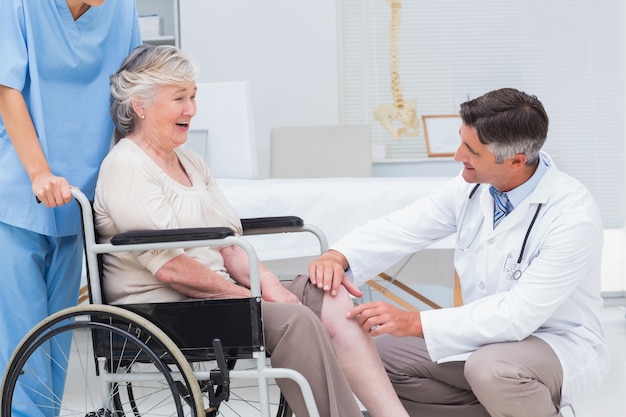 Doctor examining senior womans knee