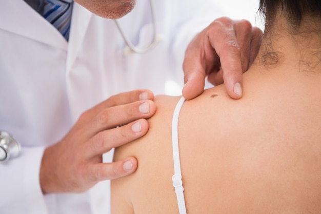 Doctor examining a spot at his patient 