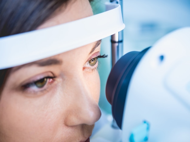 Doctor examining woman's eyes with a measurement machine.