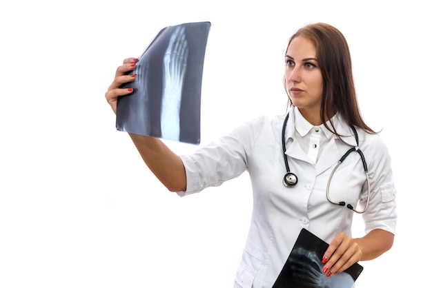 Doctor examining x-ray. Beautiful woman in medical coat with patient's x-ray isolated on white