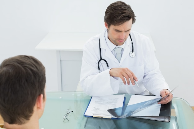 Doctor examining xray with patient at office