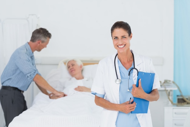 Doctor explaining report to female patient and husband