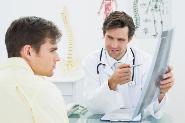 Doctor explaining spine xray to patient in office