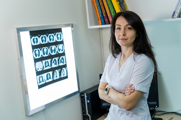 Doctor explaining an x-ray image near enlighted board.