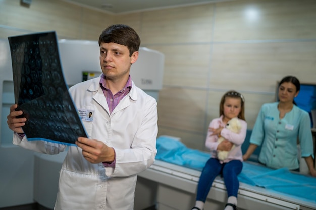 Doctor explaining an xray image near the magnetic resonance imaging machine