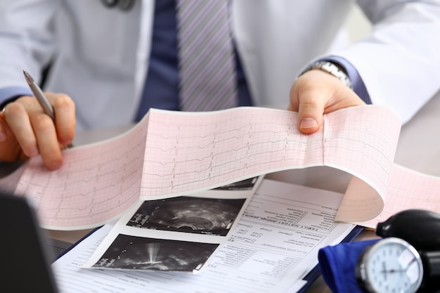 Doctor explains cardiogram data, consultation. Repeated consultation, doctor develops an optimal treatment regimen, explains how to properly control state health. Prevention, treatment heart disease.