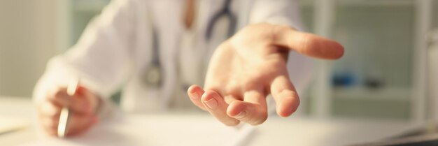 Doctor extending helping hand to patient in clinic closeup diagnosis and treatment of arterial