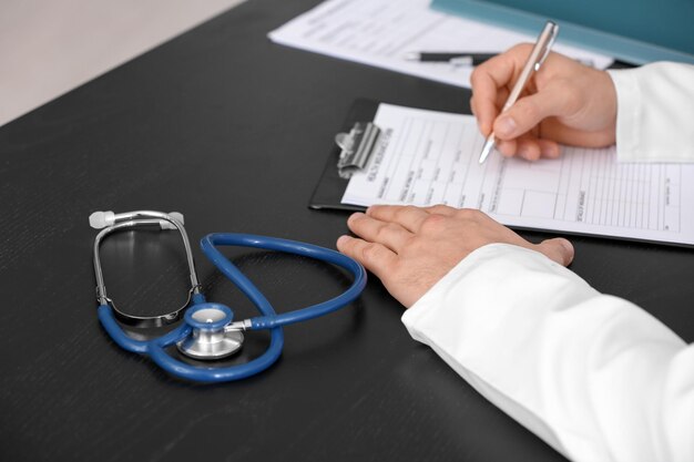 Doctor filling in insurance form at table