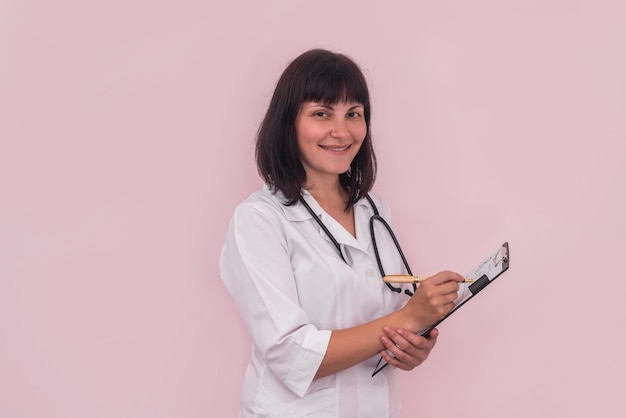 Doctor filling prescription on clipboard isolated on pink