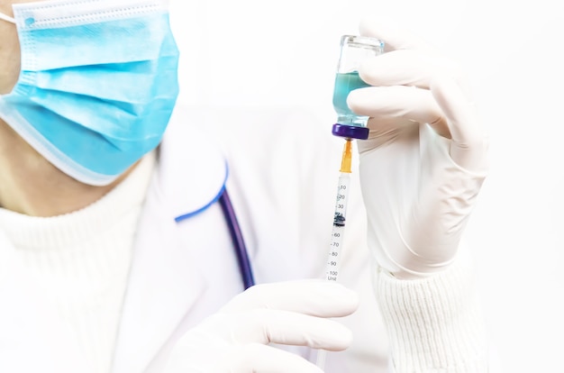 Doctor filling syringe with medication, closeup. Vaccination and immunization. Selective focus. Vaccine.