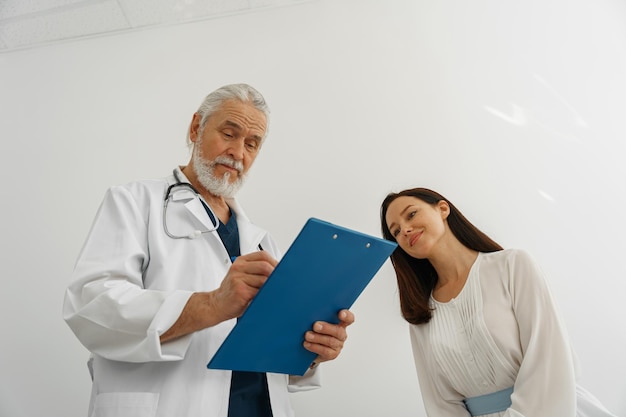 Doctor fills out the medical report form on medical care of patients during appointment