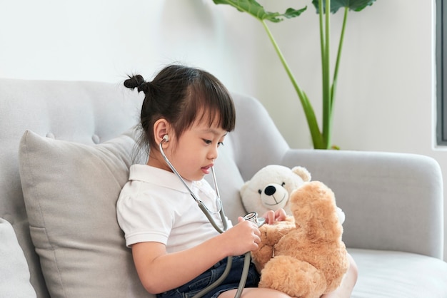 A doctor girl playing and cure bear at the pediatric