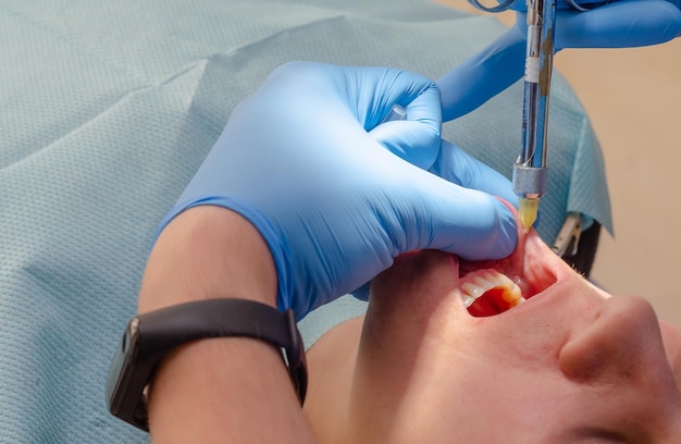 Doctor gives anesthetic injection to patient in dental clinic