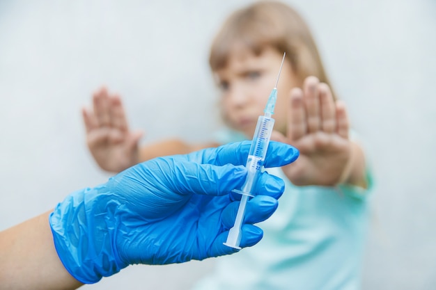 The doctor gives the child an injection in the arm