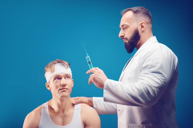 doctor gives an injection to a sick person in a medical office