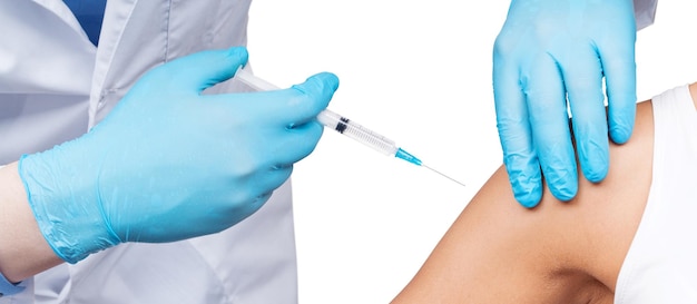 의사는 병원에서 환자에게 백신이 든 주사기를 제공합니다.