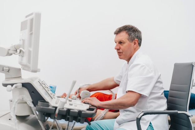 The doctor gives the woman an ultrasound of the thyroid gland