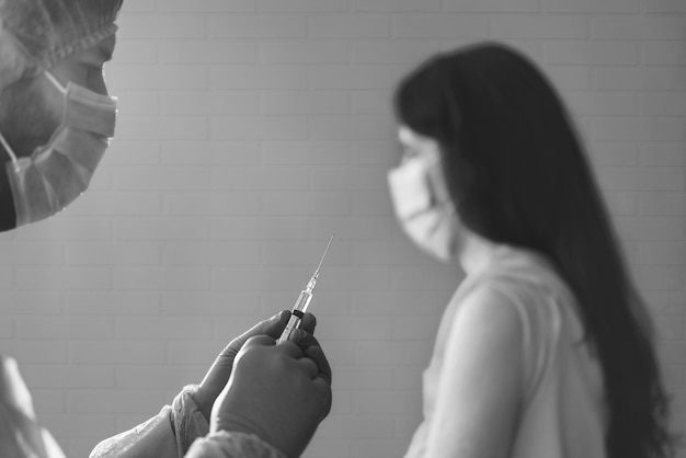 Photo doctor giving covid vaccine to young woman